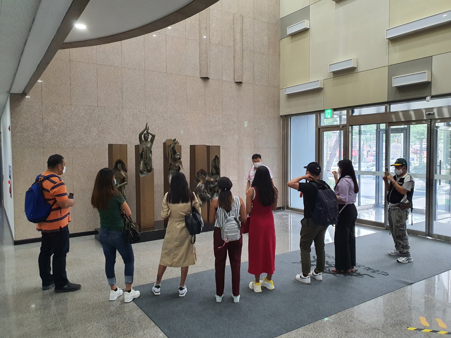 오산다문화센터 이주민 노동자 회원들이 민주화운동기념사업회 로비에서 조형물을 보며 설명을 듣고 있는 사진
